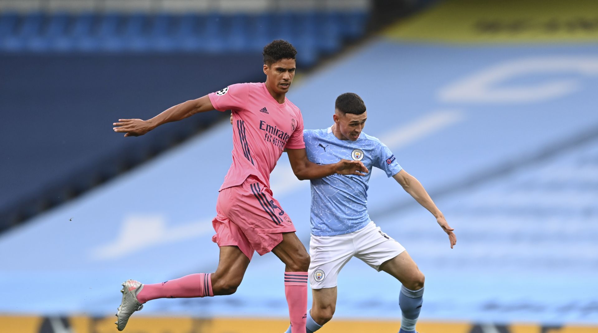 epa08590437 Real Madrid's Raphael Varane (L) and Manchester City's Phil Foden (R) in action during the UEFA Champions League Round of 16 second leg soccer match between Manchester City and Real Madrid in Manchester, Britain, 07 August 2020.  EPA/Shaun Botterill / POOL