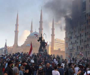 epa08592272 Smoke rises from the Beirut Gardens building as Lebanese people gather at Martyr's Square during a protest in the aftermath of the port explosion, in Beirut, Lebanon, 08 August 2020. People gathered for the so-called 'the Saturday of the hanging ropes' to protest against the political leaders and calling on those responsible over the explosion to be held accountable. Lebanese Health Ministry on 07 August said at least 154 people were killed, and more than 5,000 injured in the Beirut blast that devastated the port area on 04 August and believed to have been caused by an estimated 2,750 tons of ammonium nitrate stored in a warehouse.  EPA/IBRAHIM DIRANI DAR AL MUSSAWIR