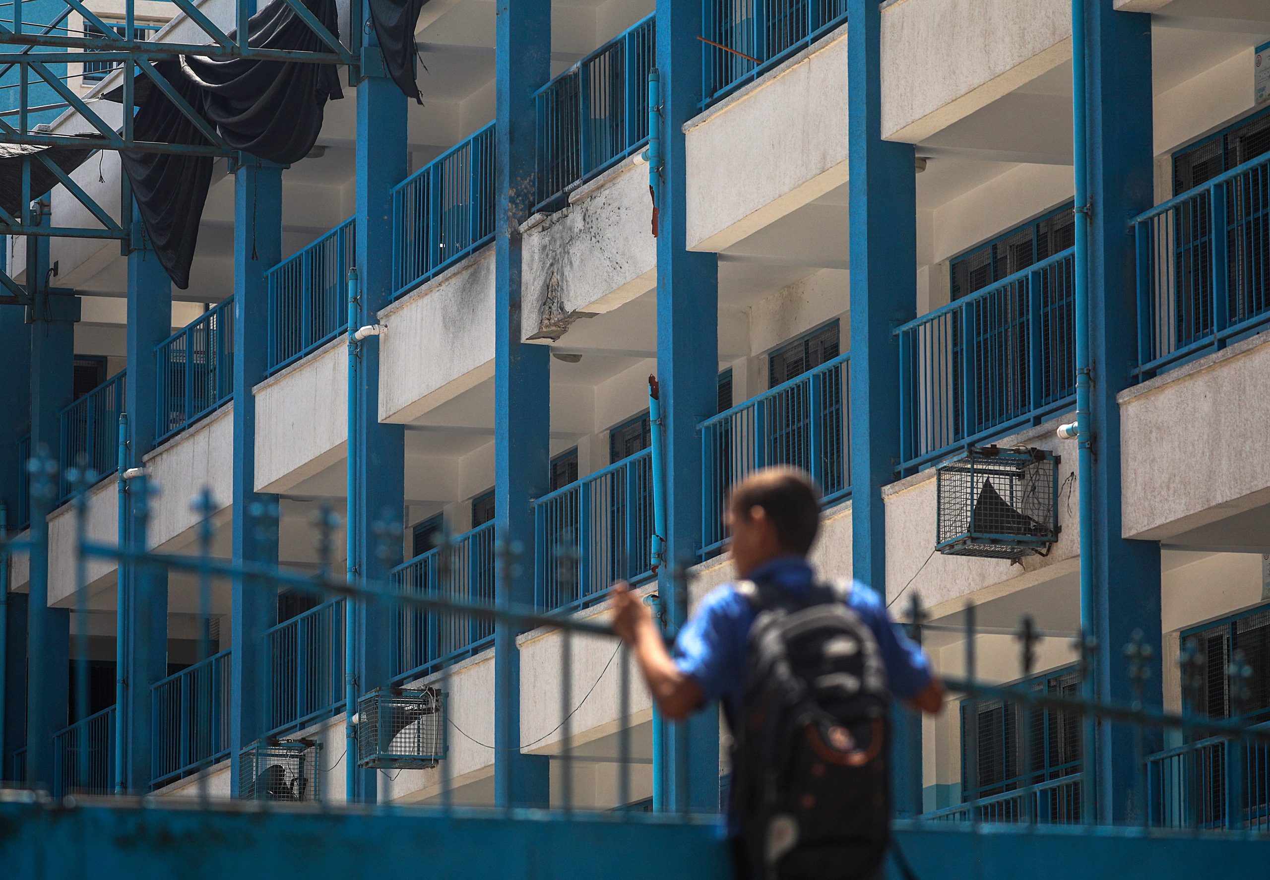 epa08600737 A Palestinian student takes a look at the damage done to his UNRWA school after it was hit by an Israeli drone in Al-Shati refugee camp, western Gaza city, 13 August 2020. An educational institution run by United Nations Relief and Works Agency (UNRWA) was hit by an Israeli drone as Israeli warplanes were targeting several locations of Hamas in Gaza city, according to reports.  EPA/MOHAMMED SABER