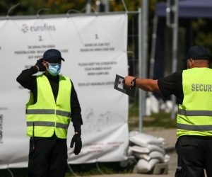 epa08612439 Security guards talk to each other at a COVID-19 test station in Hochfelln, Germany, 19 August 2020. The test stations installed by Bavaria’s State Government near  border crossings, at airports and railway stations have experienced problems informing travellers about their positive test results, some 46 positive results still can’t be matched to testees.  EPA/PHILIPP GUELLAND
