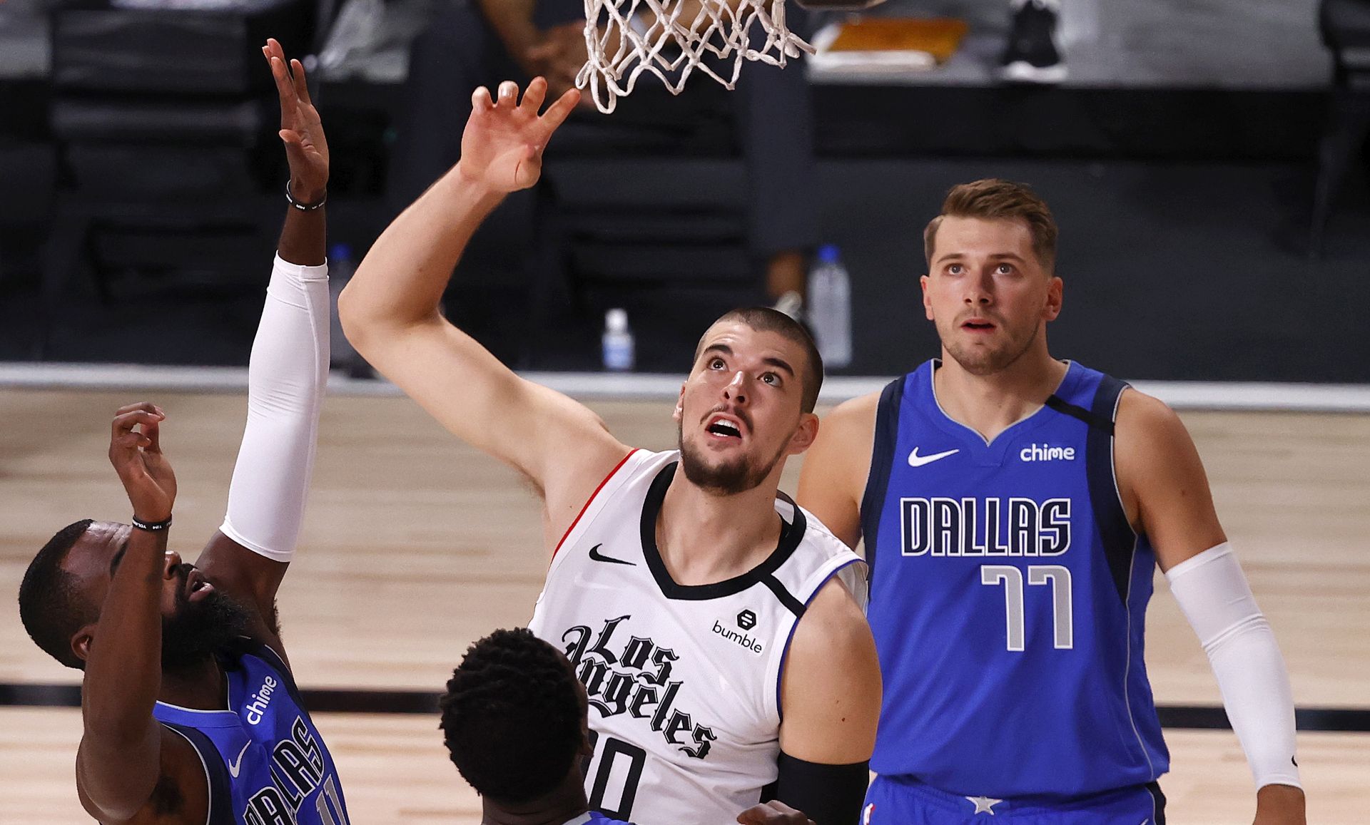 epa08617605 Los Angeles Clippers center Ivica Zubac (C) of Croatia watches his ball go in the basket for two points as Dallas Mavericks guard Tim Hardaway Jr. (L-R), Dallas Mavericks forward Dorian Finney-Smith, and Dallas Mavericks guard Luka Doncic (R) of Slovenia look on during the first half of the NBA basketball first-round playoff game three between the Los Angeles Clippers and the Dallas Mavericks at the ESPN Wide World of Sports Complex in Kissimmee, Florida, USA, 21 August 2020.  EPA/JOHN G. MABANGLO SHUTTERSTOCK OUT