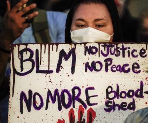 epa08626027 A protestor holds a sign during a third night of unrest in the wake of the shooting of Jacob Blake by police officers, in Kenosha, Wisconsin, USA, 25 August 2020. According to media reports Jacob Blake, a black man, was shot by a Kenosha police officer or officers responding to a domestic distubance call on 23 August, setting off protests and unrest. Blake was taken by air ambulance to a Milwaukee, Wisconsin hospital and protests started after a video of the incident was posted on social media.  EPA/TANNEN MAURY