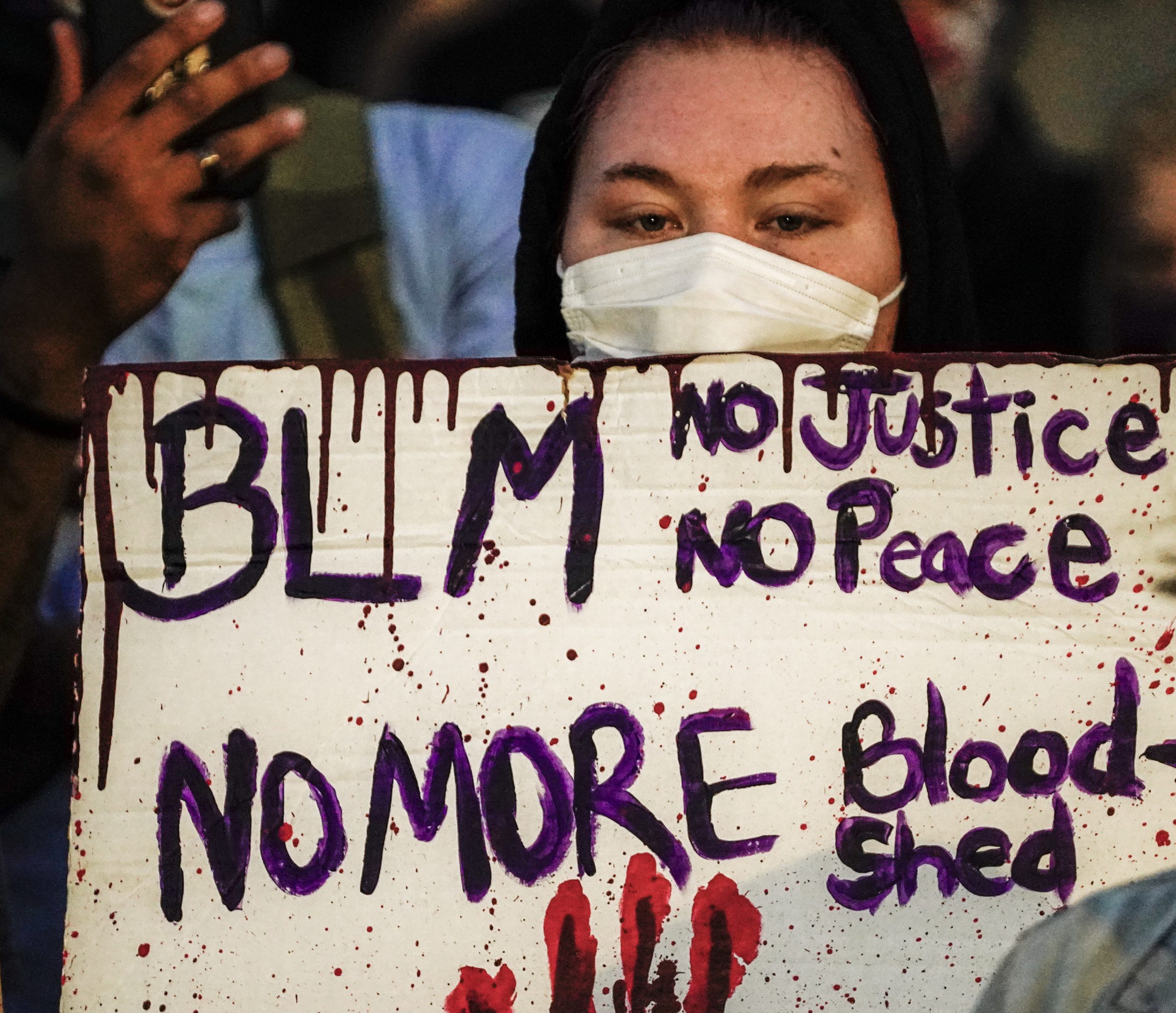 epa08626027 A protestor holds a sign during a third night of unrest in the wake of the shooting of Jacob Blake by police officers, in Kenosha, Wisconsin, USA, 25 August 2020. According to media reports Jacob Blake, a black man, was shot by a Kenosha police officer or officers responding to a domestic distubance call on 23 August, setting off protests and unrest. Blake was taken by air ambulance to a Milwaukee, Wisconsin hospital and protests started after a video of the incident was posted on social media.  EPA/TANNEN MAURY