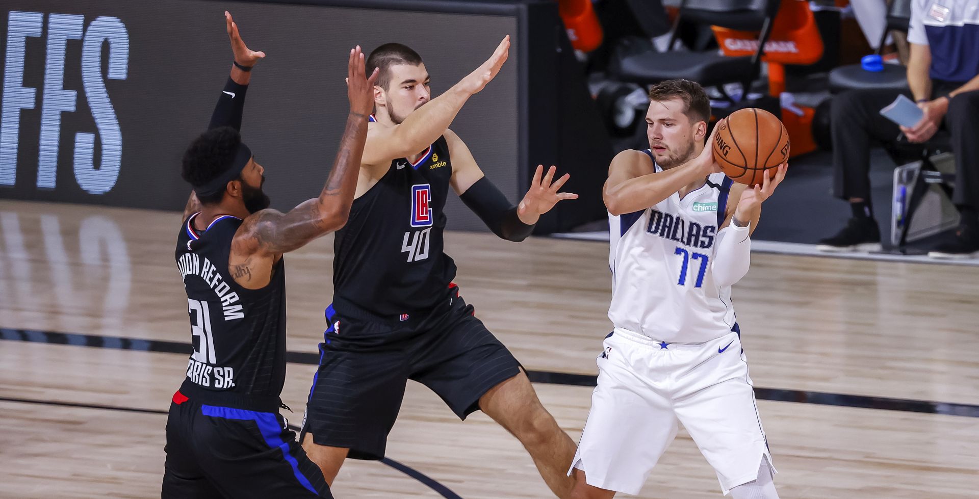 epa08636352 Dallas Mavericks guard Luka Doncic of Slovenia (R) in action against Los Angeles Clippers center Ivica Zubac of Croatia (C) and Los Angeles Clippers forward Marcus Morris Sr. (L) during the first half of the NBA basketball first-round Western Conference playoff game six between the Los Angeles Clippers and the Dallas Mavericks at the ESPN Wide World of Sports Complex in Kissimmee, Florida, USA, 30 August 2020.  EPA/JOHN G. MABANGLO SHUTTERSTOCK OUT