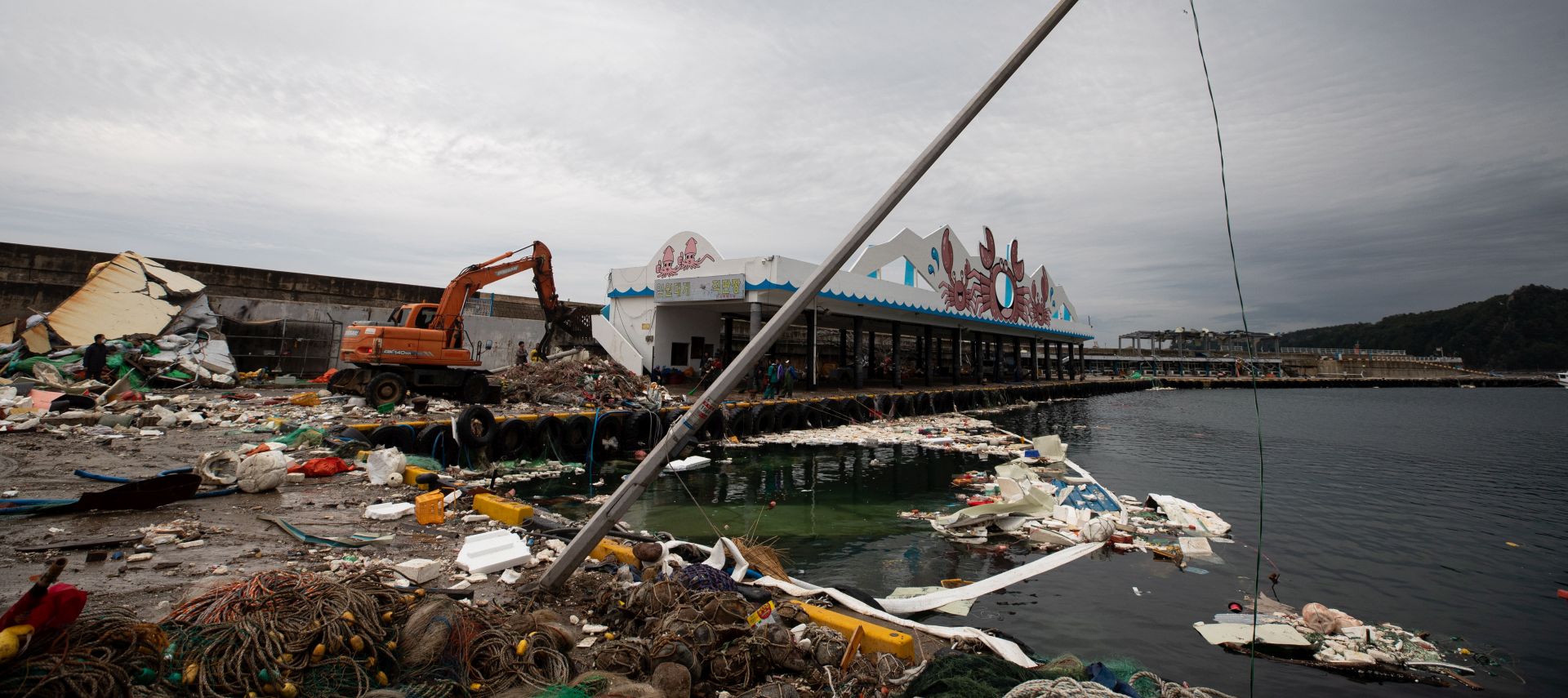 epa08650254 Local residents and forklift, clean up the fishing items that have been damaged by strong winds from the powerful Typhoon Maysak on 02 September at Imwon harbor on Donghae city in Gangwon-do province, South Korea, 06 September 2020. Korea's Meteorological Administration (KMA) said, Typhoon Haishen approaches toward Korean Peninsula at a speed of 22 kilometers per hour from around 290 kilometers northeast of Okinawa.  EPA/JEON HEON-KYUN