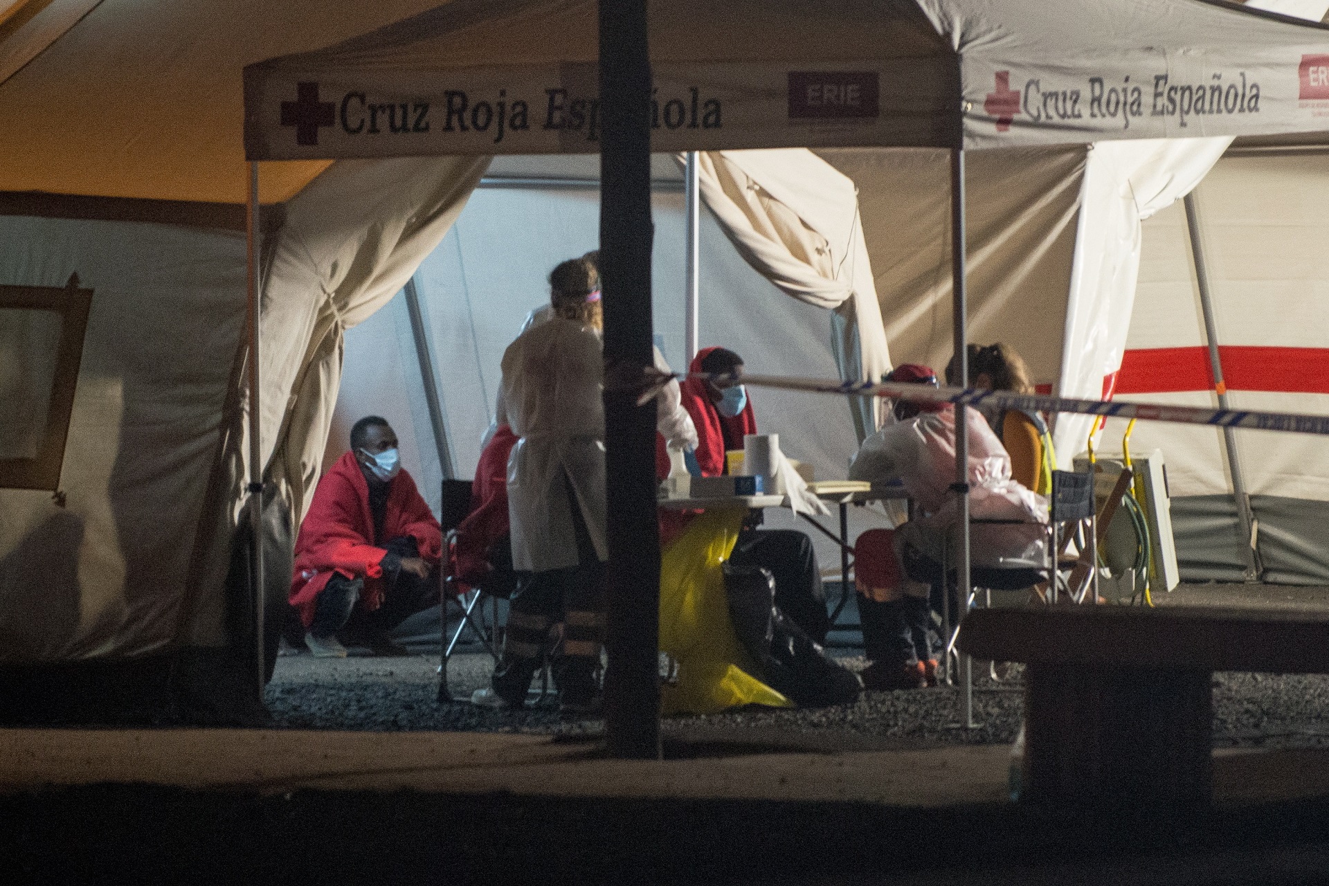 epa08651927 Red Cross and Rescue Navy members help some of the 50 Subsaharian migrants who travelled in a small boat which have been rescued 65 kilometes far away and brought to the Arrecife dock in Tenerife, Canary Islands, Spain on 07 September 2020.  EPA/Javier Fuentes Figueroa