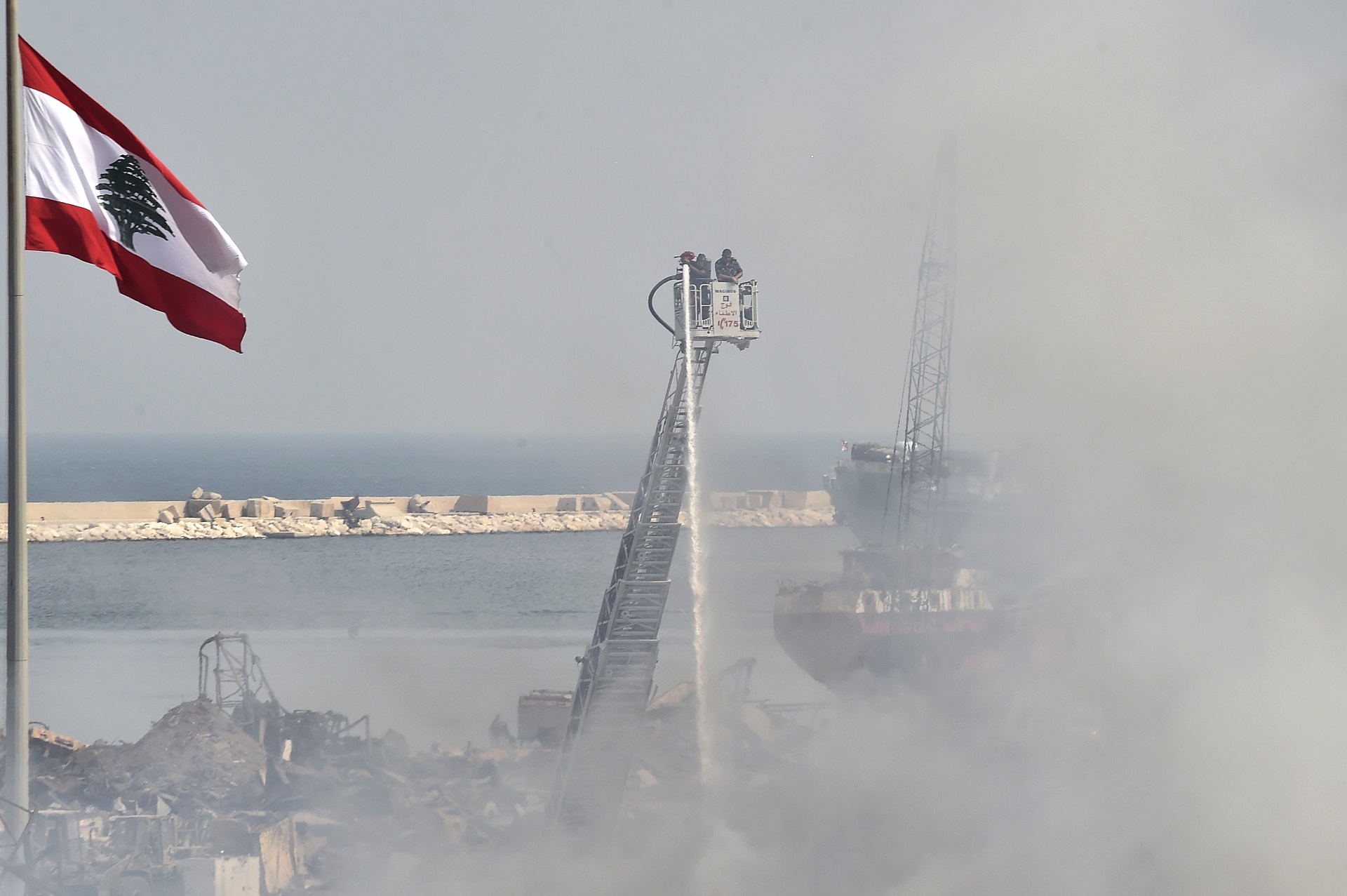 epa08660923 Firefighters extinguish a fire in a warehouse at the port of Beirut, Lebanon, 11 September 2020. A fire broke out on 10 September in an oils and tires warehouse in the port's duty-free zone, just weeks after the 04 August Beirut port blast in which at least 190 people died, more than 6,000 were injured, and the port area and large parts of the city were devastated. According to reports, the fire is brought under control.  EPA/WAEL HAMZEH