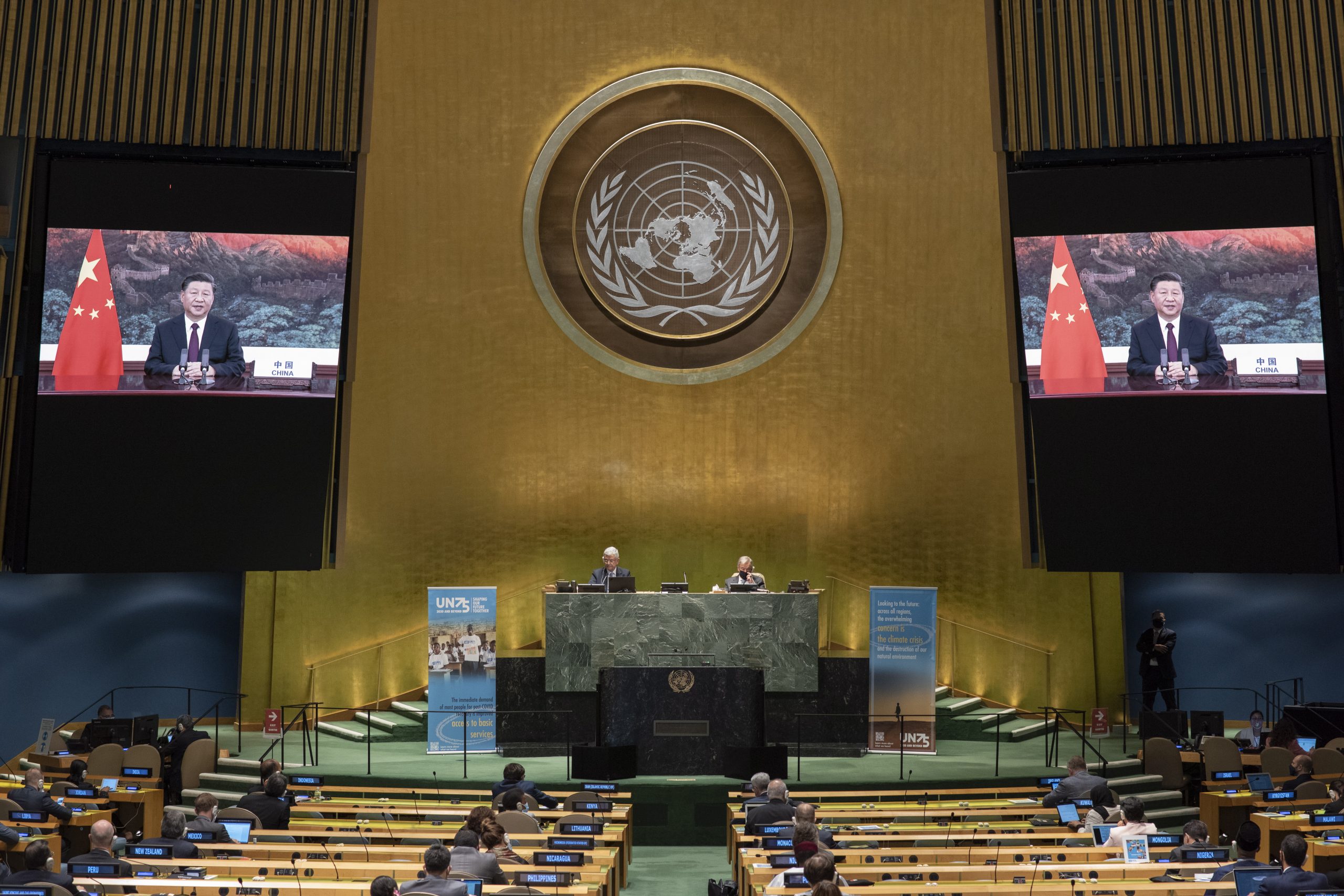 epa08687245 A handout photo made available by UN photo shows Xi Jinping (on screens), President of the People's Republic of China, speaking during the 75th General Assembly of the United Nations, in New York, New York, USA, 21 September 2020. Due to the COVID-19 coronavirus pandemic, the 75th General Assembly of the United Nations meetings are held mostly virutal. Seated at dais are Volkan Bozkir (at left), President of the seventy-fifth session of the United Nations General Assembly, and Secretary-General Antonio Guterres.  EPA/Eskinder Debebe / UN Photo / HANDOUT  HANDOUT EDITORIAL USE ONLY/NO SALES