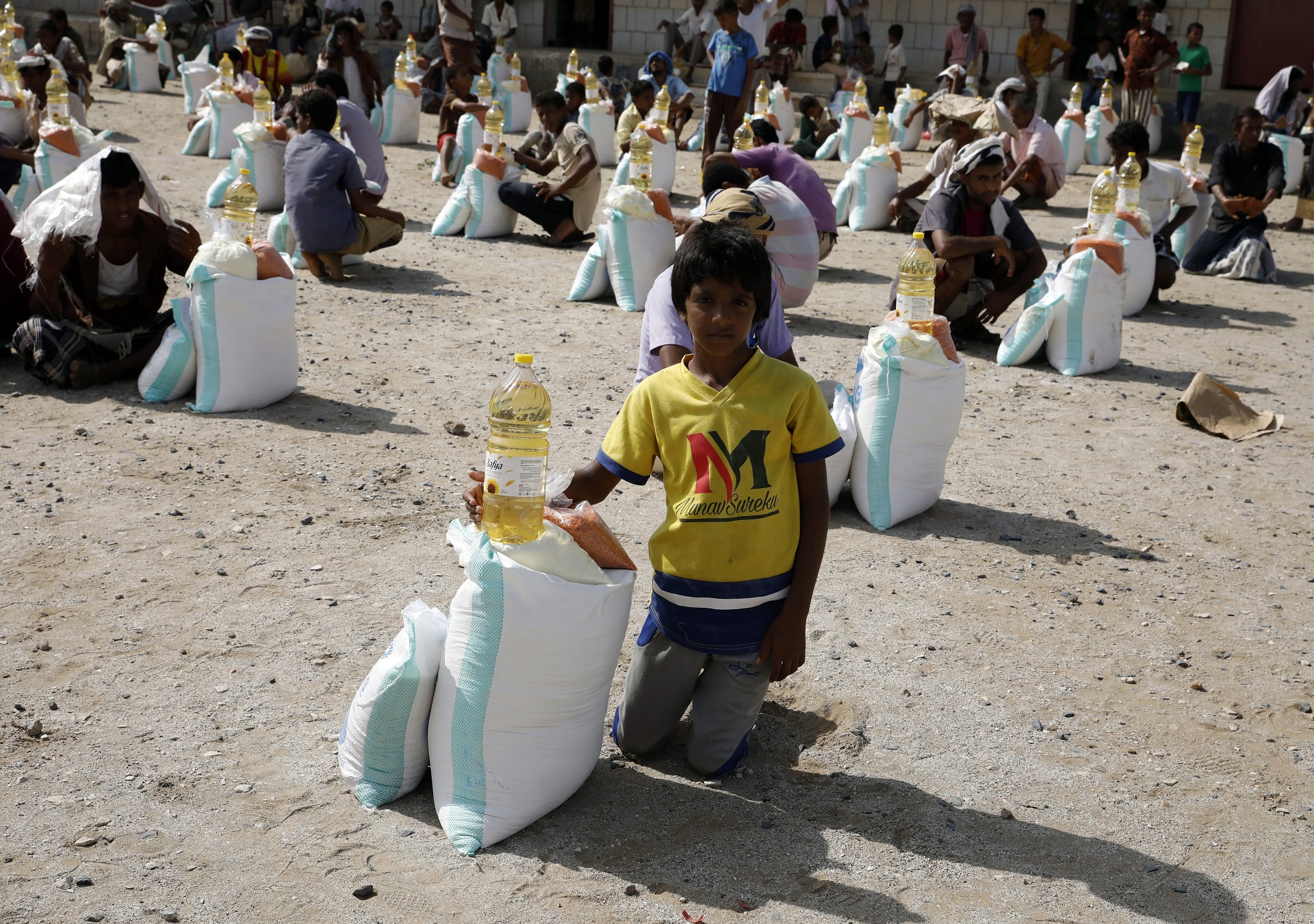epa08688859 Yemenis get emergency food items provided by a local relief group, Mona Relief Yemen, amid aid shortages, in the western province of Hajjah, Yemen, 08 September 2020 (Issued 22 September 2020). According to reports, the United Nations ranks Yemen as the worst humanitarian crisis in the world due to more than five years of conflict which shattered the country’s economy and public services, leaving nearly 80 percent of its 29 million population reliant on food aid, the majority of whom live in the Houthis-controlled north.  EPA/YAHYA ARHAB