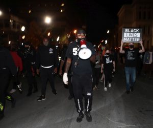 epa08695512 A protester leads supporters of Breonna Taylor in downtown Louisville, Kentucky, USA, 24 September 2020. Over 100 people were arrested on 23 September during protests after a grand jury refused to indict Louisville Metro Police officers in Taylor's death.  EPA/Mark Lyons