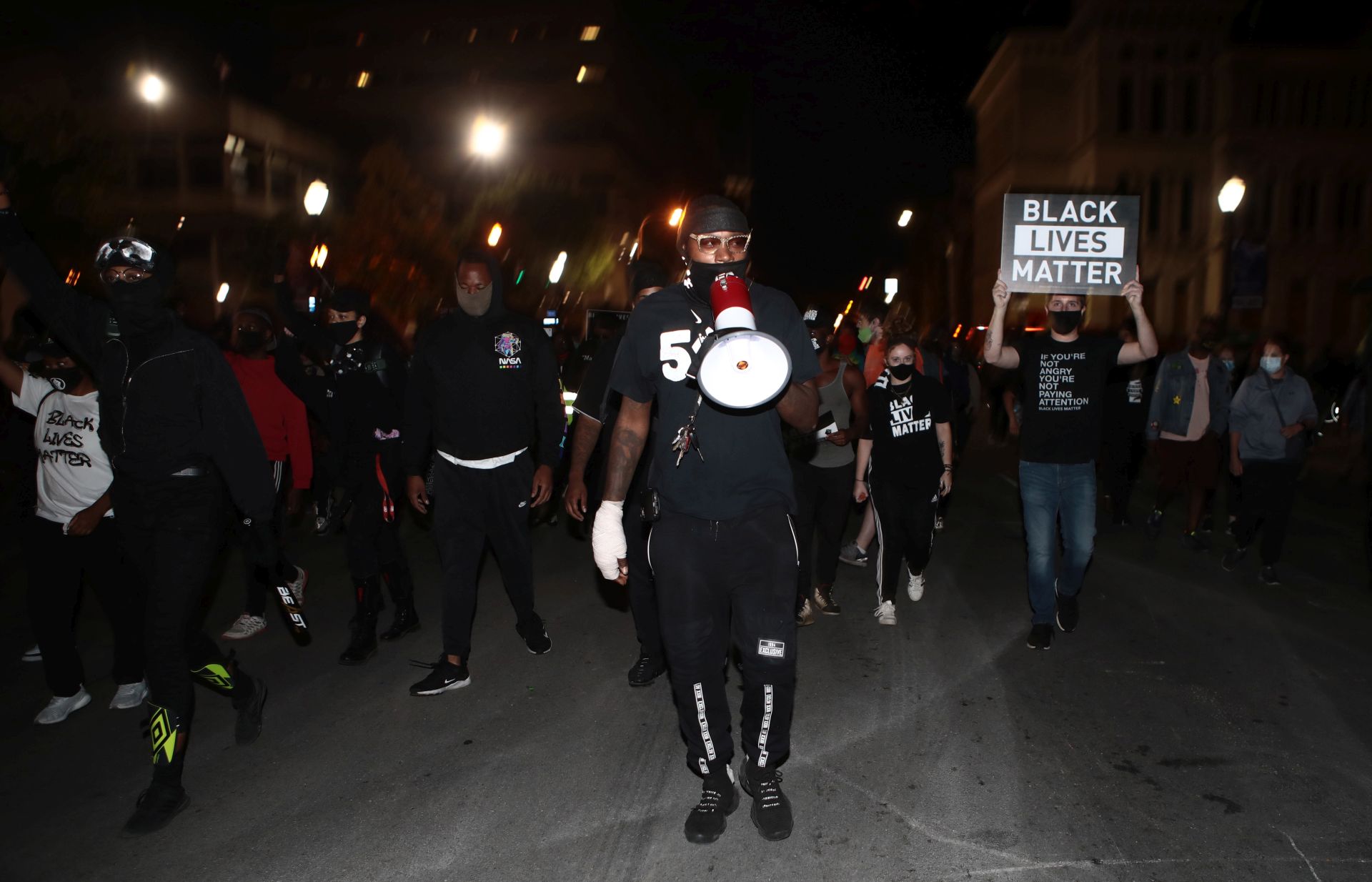 epa08695512 A protester leads supporters of Breonna Taylor in downtown Louisville, Kentucky, USA, 24 September 2020. Over 100 people were arrested on 23 September during protests after a grand jury refused to indict Louisville Metro Police officers in Taylor's death.  EPA/Mark Lyons