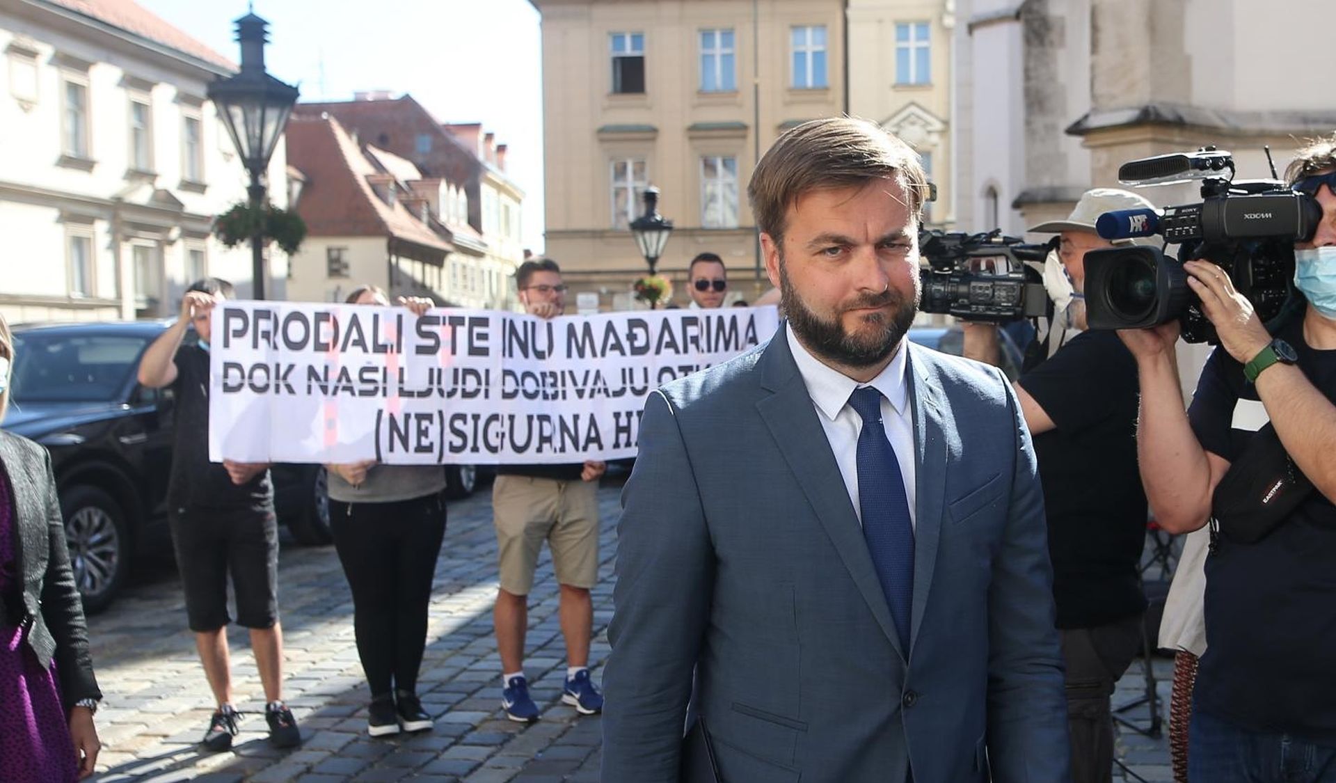 27.08.2020., Zagreb - Ministar gospodarstva i odrzivog razvoja Tomislav Coric dolazi na sjednicu Vlade RH. Ispred Banskih dvora docekali su clanovi Foruma mladih SDP-a s transparentom "Prodali ste INA-u  Madajrima, dok nasi ljudi dobivaju otkaze". Photo: Zeljko Lukunic/PIXSELL