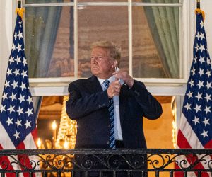 epa08723128 US President Donald J. Trump takes off his mask after returning to the White House, in Washington, DC, USA, 05 October 2020. Trump was returning to the White House following several days at Walter Reed National Military Medical Center for treatment for COVID-19.  EPA/KEN CEDENO / POOL