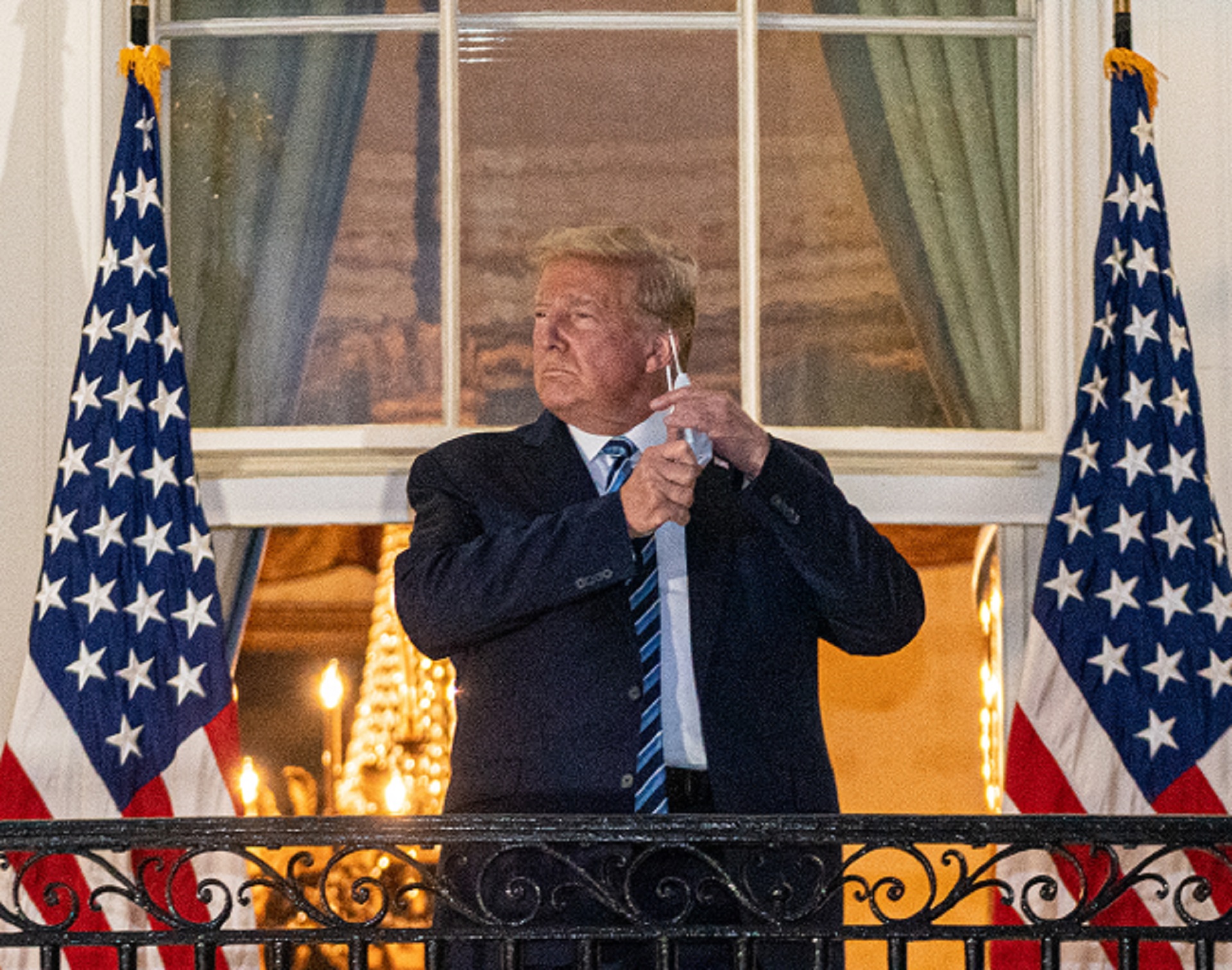 epa08723128 US President Donald J. Trump takes off his mask after returning to the White House, in Washington, DC, USA, 05 October 2020. Trump was returning to the White House following several days at Walter Reed National Military Medical Center for treatment for COVID-19.  EPA/KEN CEDENO / POOL
