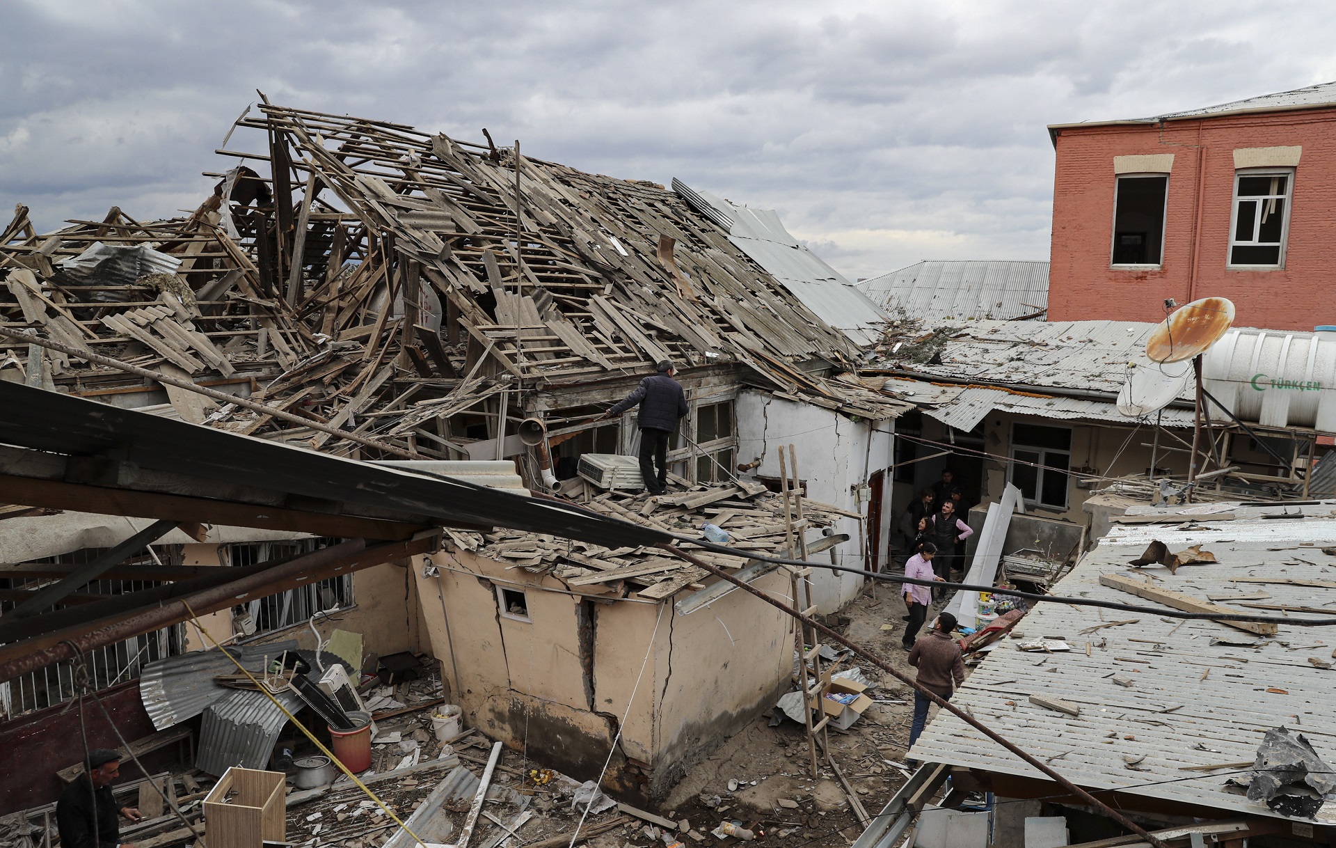 epa08724889 People examine their house allegedly damaged by an alleged recent shelling in the downtown of Ganja in Agdam region in Nagorno Karabakh, 06 October 2020. Armed clashes erupted on 27 September 2020 in the simmering territorial conflict between Azerbaijan and Armenia over the Nagorno-Karabakh territory along the contact line of the self-proclaimed Nagorno-Karabakh Republic (also known as Artsakh).  EPA/AZIZ KARIMOV