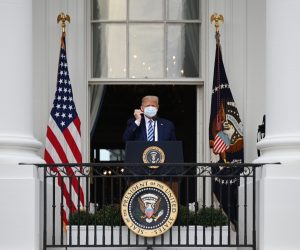 epa08734758 US President Donald J. Trump removes a protective mask ahead of speaking from the Truman Balcony of the White House in Washington, DC, USA, on 10 October 2020. Trump, making his first public appearance since returning from a three-day hospitalization for Covid-19, is setting the stage for a return to the campaign trail even as questions remain about whether he's still contagious.  EPA/Erin Scott / POOL