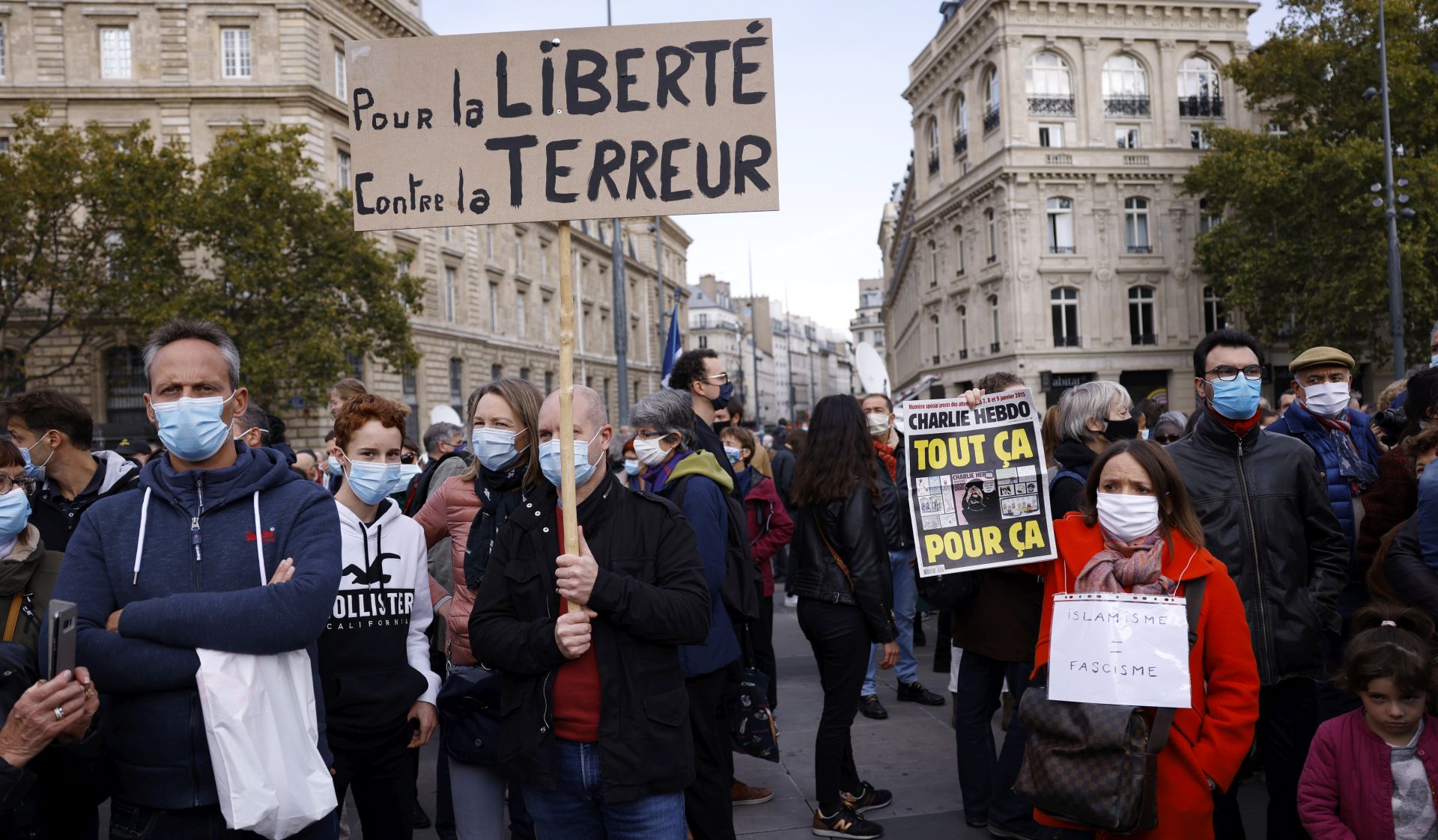 epa08755251 A person (R) holds the controversial cover of the Charlie Hebdo satirical weekly showing the caricatures of the Prophet Mohammed as people gather at the Place de la Republique for a demonstration against terrorism and to pay their respect after French teacher Samuel Paty was beheaded, in Paris, France, 18 October 2020. On 16 October French school teacher Samuel Paty was decapitated by 18-year-old attacker named Abdoulakh Anzorov who has been shot dead by policemen. Paty was a history teacher who had recently shown caricatures of the Prophet Mohammed in class.  EPA/YOAN VALAT