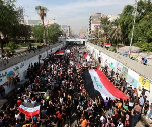 epa08773516 Iraqi protesters carry national flags as they protest in Baghdad, Iraq, 25 October 2020. Dozens of protesters were wounded in clashes with security forces after a demonstration which was held to mark the 25 October 2019 mass protests that resumed a day after some 50 protesters were killed and injured when attempting to enter Baghdad's heavily fortified 'Green Zone', and demand to put those on trial who are responsible for the killed protesters.  EPA/AHMED JALIL