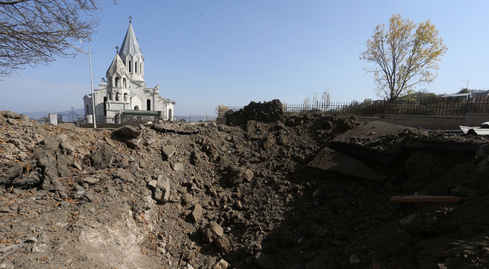 epa08782821 General view of church, in the backround, and a crater, in the foreground, in the town of Shushi (another spelling Shusha) in the Nagorno-Karabakh Republic, 29 October 2020, after allegedly Azerbaijani shelling. Armed clashes erupted on 27 September 2020 in the simmering territorial conflict between Azerbaijan and Armenia over the Nagorno-Karabakh territory along the contact line of the self-proclaimed Nagorno-Karabakh Republic (also known as Artsakh).  EPA/HAYK BAGHDASARYAN /PHOTOLURE
