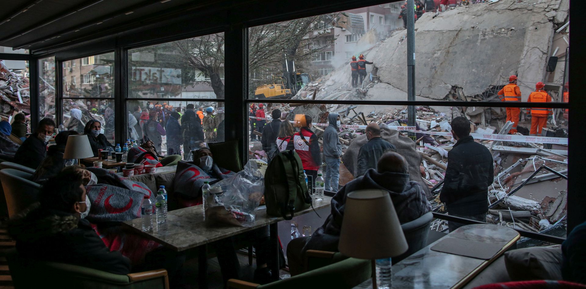 epaselect epa08787364 People sit at a cafe and wait for news from their relatives believed to be trapped under collapsed buildings after a 7.0 magnitude earthquake in the Aegean Sea; at Bayrakli district in Izmir, Turkey, 31 October 2020. According to Turkish media reports, at least twenty four people died while more than eight hundred were injured and dozens of buildings were destroyed in the earthquake.  EPA/ERDEM SAHIN