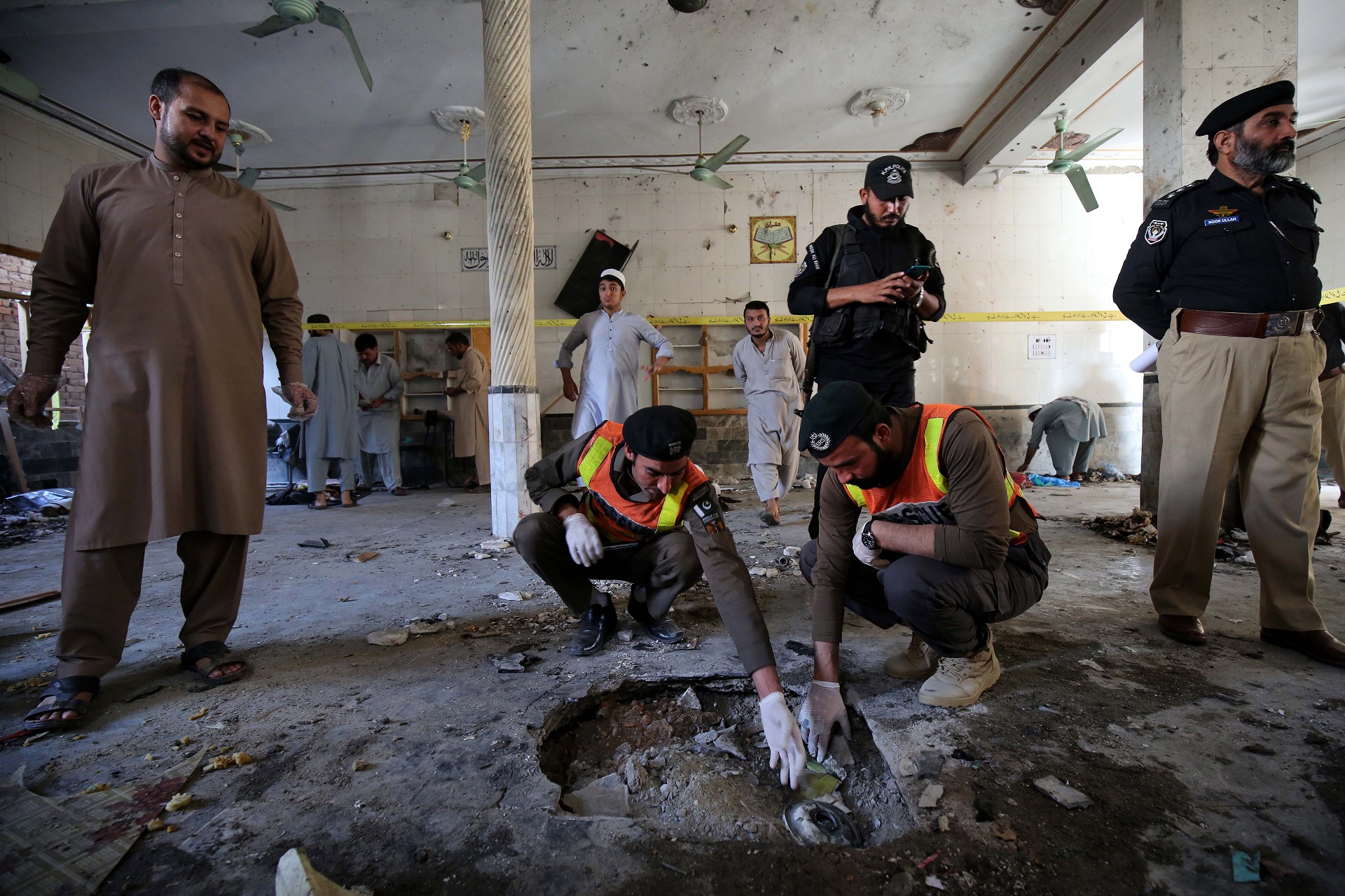 epa08776794 Pakistani security officials inspect the crater formed at the scene of an explosion at an Islamic seminary in Peshawar, Pakistan, 27 October 2020. At least seven people died, including children, and more than 70 were injured in an explosion at a seminary in Peshawar. No group has yet claimed responsibility.  EPA/BILAWAL ARBAB
