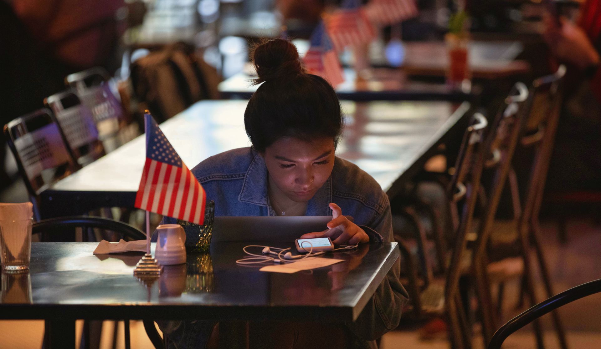 epa08797605 A woman follows US elections results in a restaurant in Shanghai, China, 04 November 2020. Republican candidate and incumbent Donald J. Trump and Democratic Party candidate Joe Biden are jostling for Electoral College votes need to secure the presidency. To win a candidate needs to acquire 270 Electoral College votes.  EPA/ALEX PLAVEVSKI
