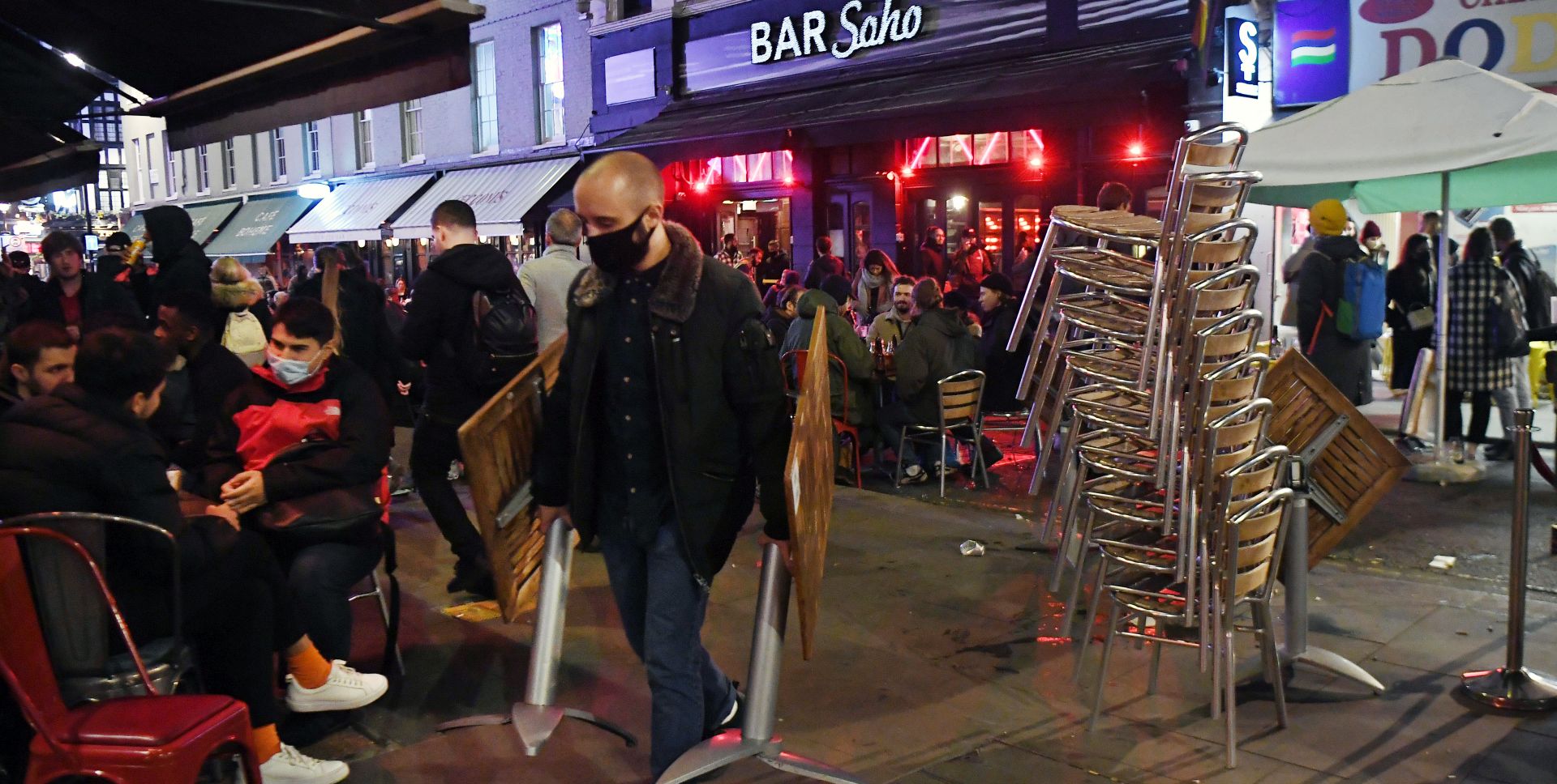 epa08799516 A bar staffer packs away tables and chairs at a bar in Soho before lockdown in London, Britain, 04 November 2020. The UK government have announced that the UK will begin its second national lockdown from 05 November. This comes as news reports state that COVID-19 related deaths in Britain have increased by 46 percent in less than a week.  EPA/ANDY RAIN