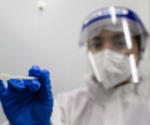 epa08800271 A health worker poses with a swab at a Covid-19 test center at Berlin Brandenburg Airport BER airport in Berlin, Germany, 05 November 2020. The company Centogene runs a walk-in COVID-19 test center at Berlin Brandenburg Airport and other airports in Germany.  EPA/CLEMENS BILAN