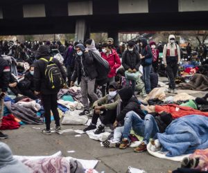 epa08824931 Thousands of migrants wait to be evacuated by French police forces at a makeshift migrant camp set along the A1 freeway in Saint-Denis, north of Paris, France, early 17 November 2020. French forces dismantled a migrant camp in Paris's northern suburb early in the morning and evacuated about 2,500 refugees.  EPA/YOAN VALAT *** Local Caption *** 55607528
