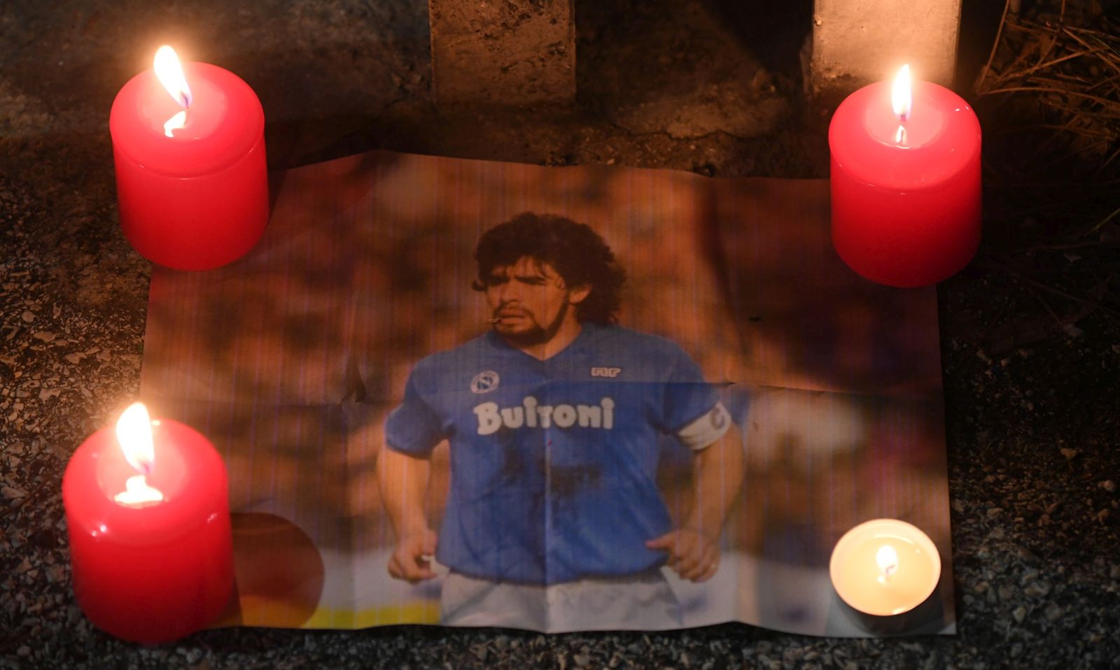 epa08842274 A picture of Maradona as Napoli soccer supporters stand outside the San Paolo stadium to pay tribute to Maradona in Naples, Italy, 25 November 2020. Diego Maradona has died after a heart attack, media reports claimed on 25 November 2020.  EPA/CIRO FUSCO