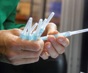 epa08847445 An operator at the Becton Dickinson company plant in Fraga (Huesca) inspects vaccine injection devices manufactured to administer the coronavirus vaccine, in Fraga, Huesca, Spain, 28 November 2020. The Becton Dickinson (BD) plant in the Aragones town has already manufactured more than 400 million syringes for the vaccination process.  EPA/Javier Cebollada