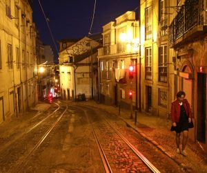epa08835284 A woman walks in a deserted street during the lockdown of the state of emergency, as part of the measures to contain covid-19, in Lisbon, late 21 November 2020. With 213 municipalities at risk in Portugal, the Council of Ministers decreed over the weekend the closure of all shops and restaurants from 1 pm to 8 am the following day, in addition to the mandatory confinement for the entire population of these municipalities from 1 pm.  EPA/ANTONIO PEDRO SANTOS
