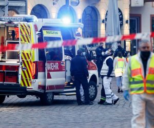 epa08855063 Policemen and a firefighting vehicle behind warning tape in a pedestrian zone in the city center in Trier, Germany, 01 December 2020.  According to reports, at least two people have been killed and several injured after a car with high speed hit into pedestrians in the inner city of Trier. Police arrested the  driver and the car was seized.  EPA/JULIEN WARNAND