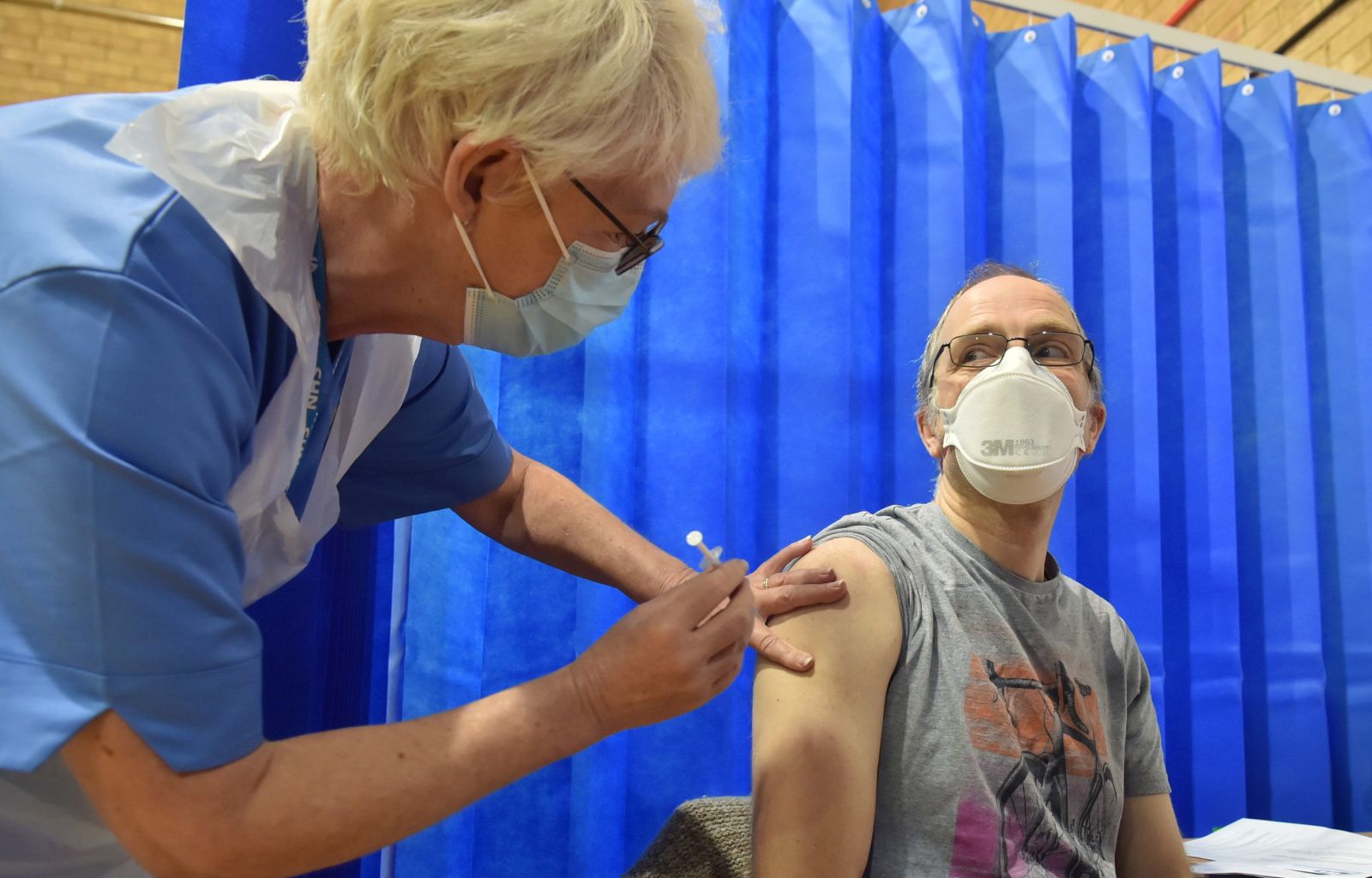 epa08870152 David Farrell, 51, from Llandow, receives the first of two Pfizer/BioNTech Covid-19 vaccine jabs at a vaccination centre in Cardiff, Britain, 08 December 2020. The UK started the largest immunisation programme in the country's history. Care home workers, NHS staff and people aged 80 and over will begin receiving the jab protecting against the SARS-CoV-2 coronavirus.  EPA/Ben Birchall / POOL
