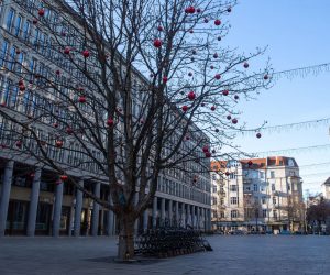 epa08893529 Outdoor chairs and tables are locked next to a tree decorated with Christmas balls at the Walter-Benjamin-Platz in Berlin, Germany, 19 December 2020. As the number of cases of the COVID-19 disease caused by the SARS-CoV-2 coronavirus is still rising throughout Germany, the government has imposed a second hard lockdown with businesses closing from 16 December on until 10 January 2021.  EPA/HAYOUNG JEON