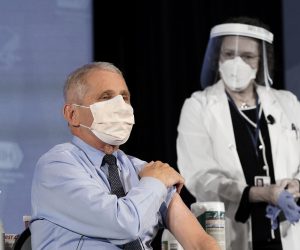 epa08899646 Dr. Anthony Fauci, director of the National Institute of Allergy and Infectious Diseases, speaks as he holds up his sleeve in preparation to receive his first dose of the COVID-19 vaccine at the National Institutes of Health, in Bethesda, Maryland, USA, 22 December 2020.  EPA/Patrick Semansky / POOL