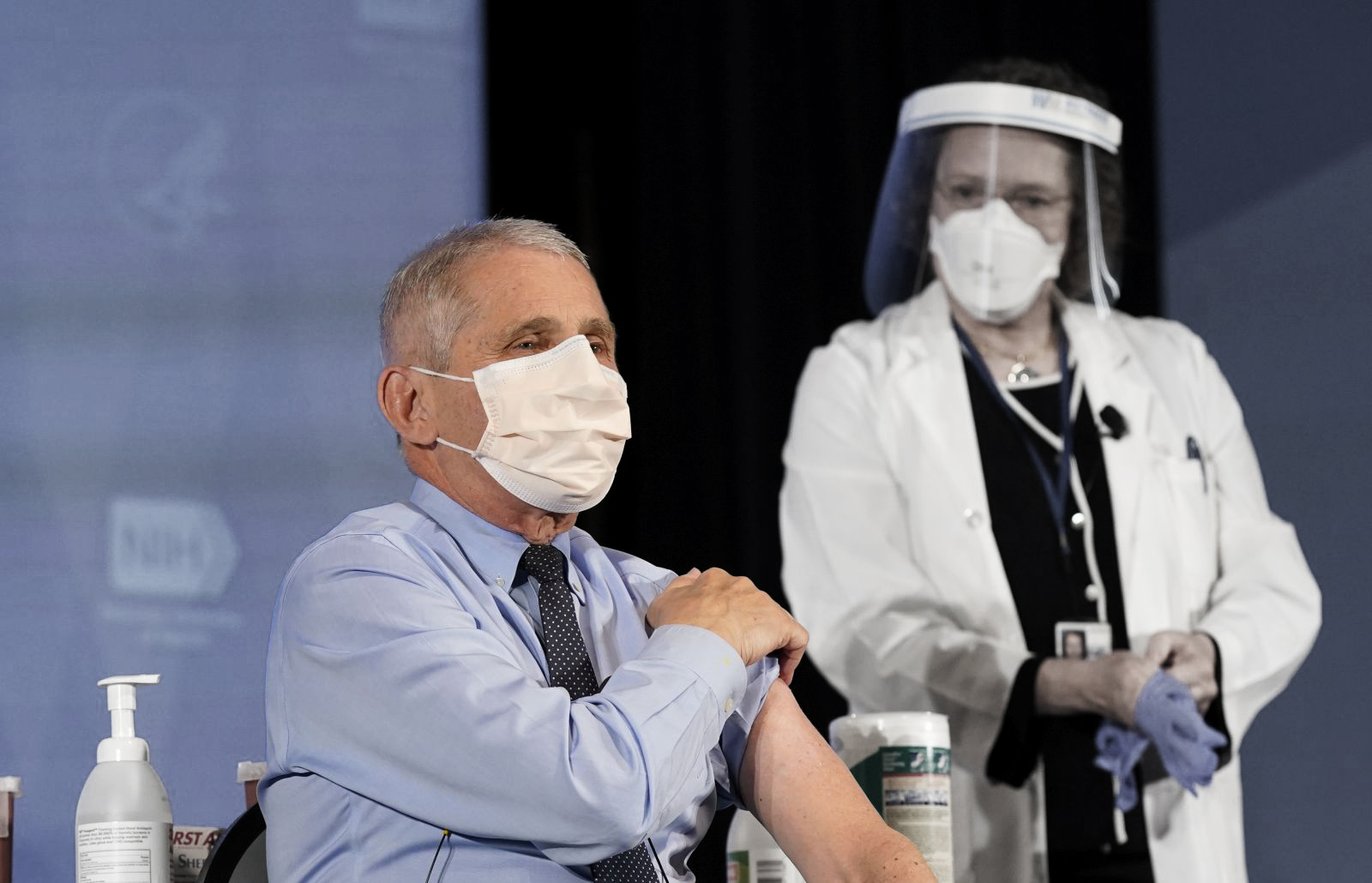 epa08899646 Dr. Anthony Fauci, director of the National Institute of Allergy and Infectious Diseases, speaks as he holds up his sleeve in preparation to receive his first dose of the COVID-19 vaccine at the National Institutes of Health, in Bethesda, Maryland, USA, 22 December 2020.  EPA/Patrick Semansky / POOL