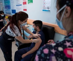 epa08903083 A health worker receives the vaccine against COVID-19 in Santiago, Chile, 24 December 2020. Chile became the second country in Latin America to start the vaccination process against COVID-19 after Mexico, by immunizing several members of the health sector just hours after receiving the first batch of the vaccine from Pfizer-BioNTech.  EPA/Alberto Valdes