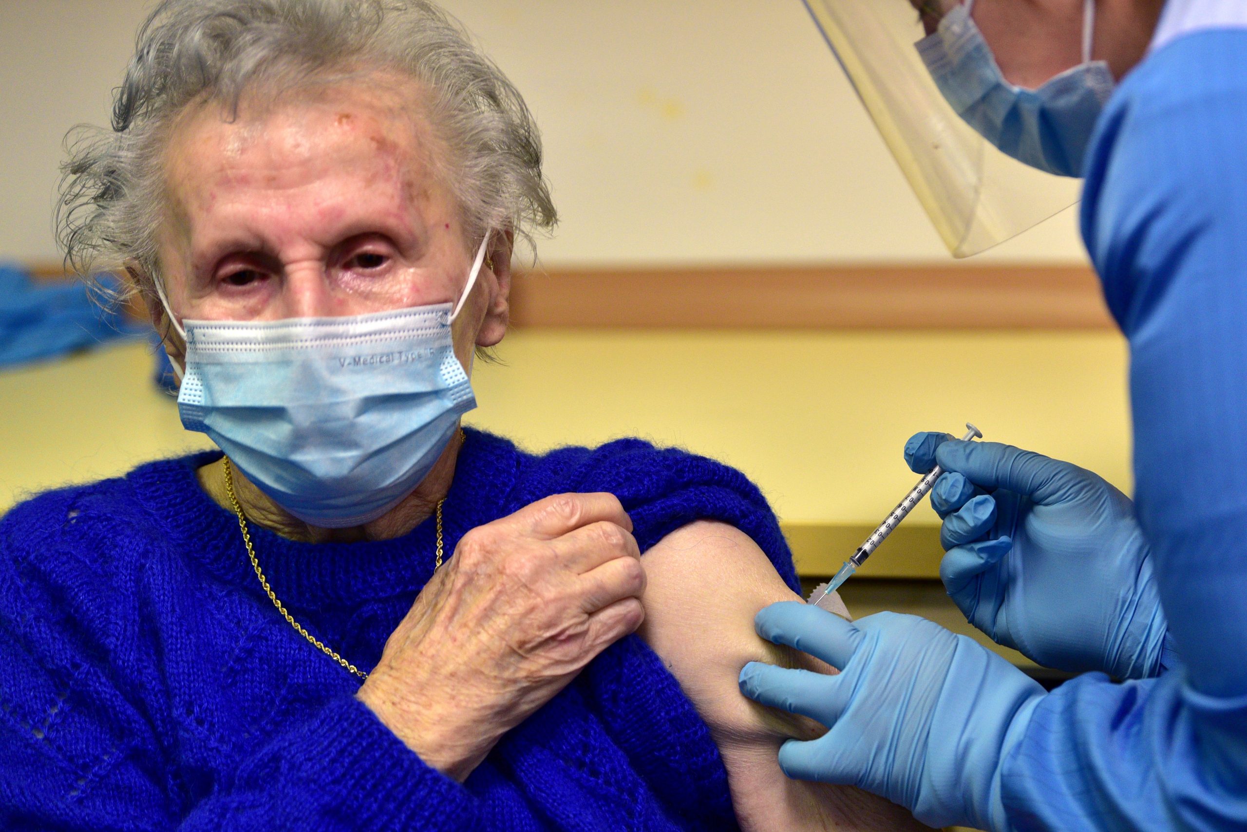 epa08905639 A Slovenian patient (L) receives a vaccine of the Pfizer-BioNTech against the COVID-19 at the Home for Elderly people Fuzine, in Ljubljana, Slovenia, 27 December 2020.  EPA/IGOR KUPLJENIK