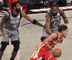epa08912035 The Hawks' Trae Young (R) drive past the Nets' Kyrie Irving (L) and Kevin Durant (C) during the first half of the game between the Atlanta Hawks and the Brooklyn Nets at the Barclays Center in Brooklyn, New York, USA, 30 December 2020.  EPA/JUSTIN LANE SHUTTERSTOCK OUT