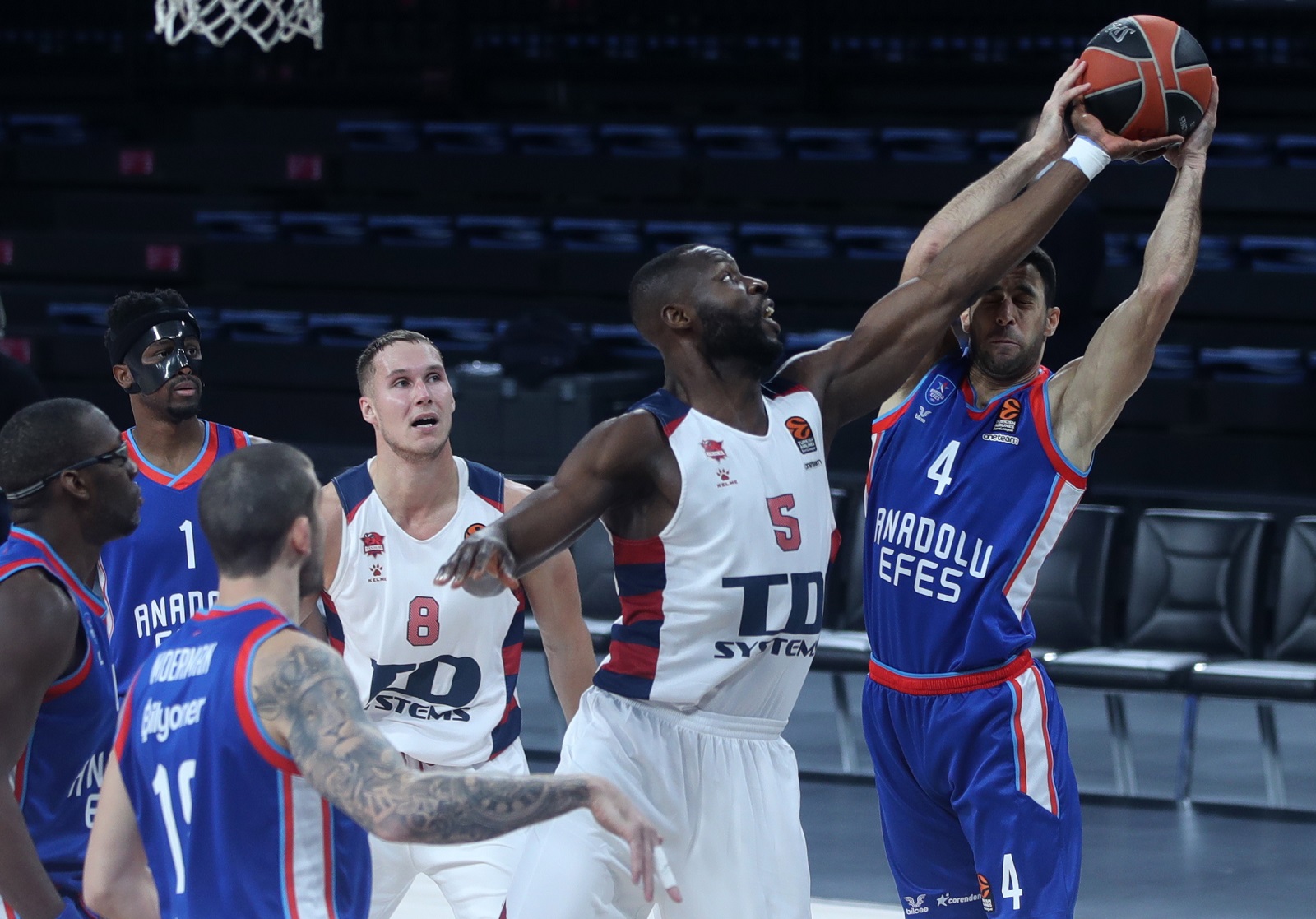 epa08862348 Dogus Balbay (R) of Anadolu Efes in action against Tonye Jekiri (2-R) of Baskonia Vitoria-Gasteiz during the Euroleague basketball match between Anadolu Efes vs Baskonia Vitoria-Gasteiz at Sinan Erdem Arena in Istanbul, Turkey, 04 December 2020.  EPA/ERDEM SAHIN