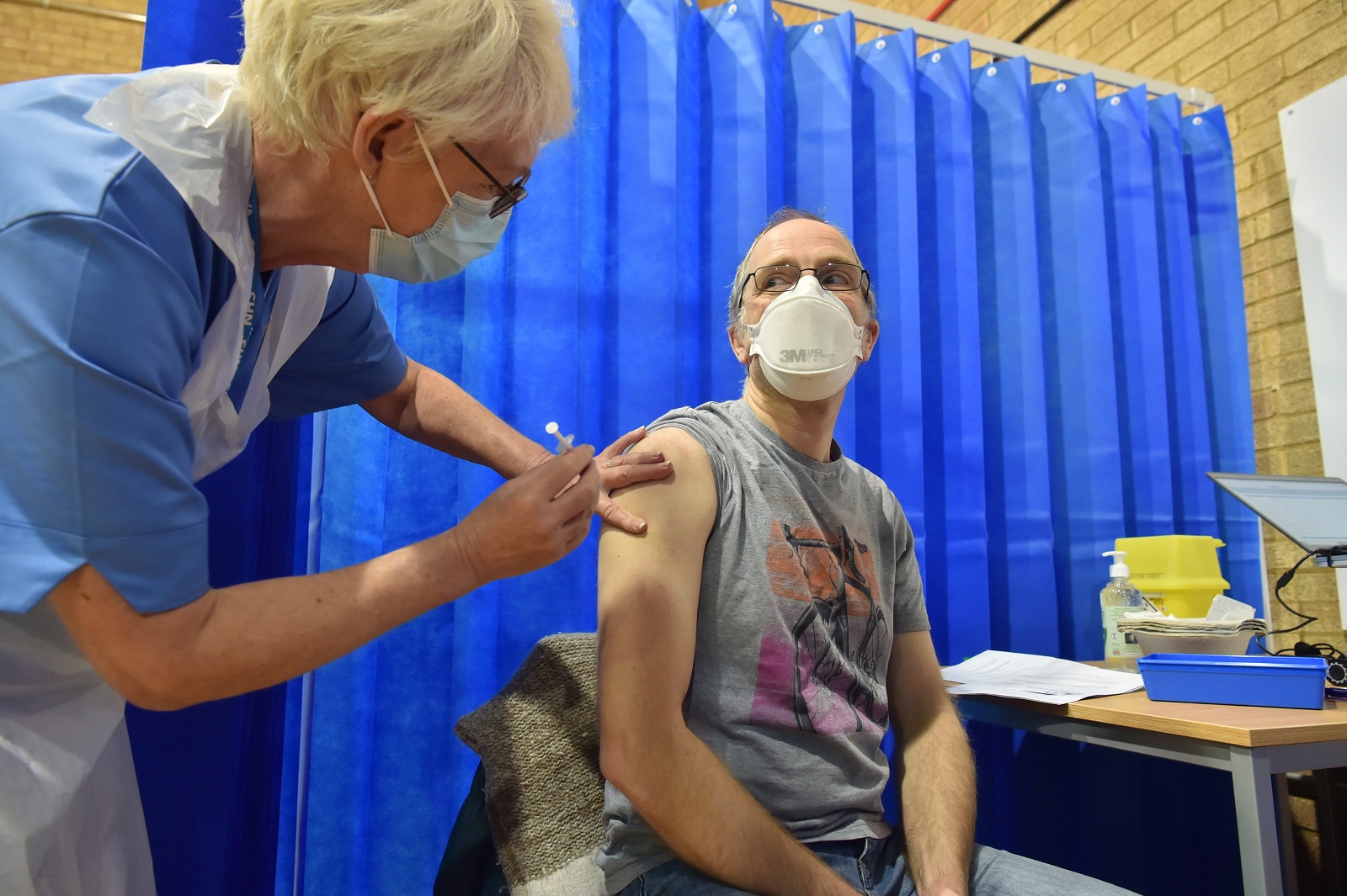 epa08870152 David Farrell, 51, from Llandow, receives the first of two Pfizer/BioNTech Covid-19 vaccine jabs at a vaccination centre in Cardiff, Britain, 08 December 2020. The UK started the largest immunisation programme in the country's history. Care home workers, NHS staff and people aged 80 and over will begin receiving the jab protecting against the SARS-CoV-2 coronavirus.  EPA/Ben Birchall / POOL
