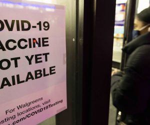 epa08856317 A person walks past sign informing customers about COVID-19 vaccine availability at a drug store in New York, USA, 01 December 2020.  EPA/JUSTIN LANE
