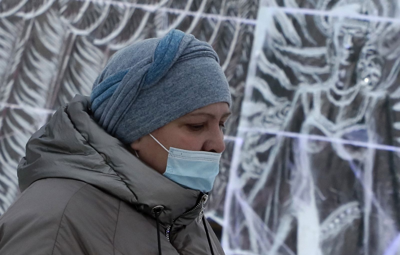 epa08911516 A visitor wearing a protective face mask attends the ice sculptures Christmas festival 'Fairy Tales of Planet Earth' amid the coronavirus Covid-19 pandemic in Podolsk, outside Moscow, Russia, 30 Dcember 2020. Russians are preparing to celebrate New Year's Eve on 31 December and Christmas which is observed on 07 January according to the Russian Orthodox Julian calendar, 13 days after Christmas on 25 December on the Gregorian calender.  EPA/MAXIM SHIPENKOV
