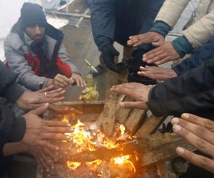 epaselect epa08914523 Migrants warm themselves by a campfire during a winter day at the Lipa refugee camp outside Bihac, Bosnia and Herzegovina, 01 January 2021. Some thousand refugees at the camp were scheduled to be relocated from the burnt-down tent camp on 31 December, yet were returned to Lipa camp. A fire on 23 December destroyed most of the camp near the city of Bihac, which has already been sharply criticized by international authorities and aid groups as unsuitable for accommodating refugees and migrants.  EPA/FEHIM DEMIR