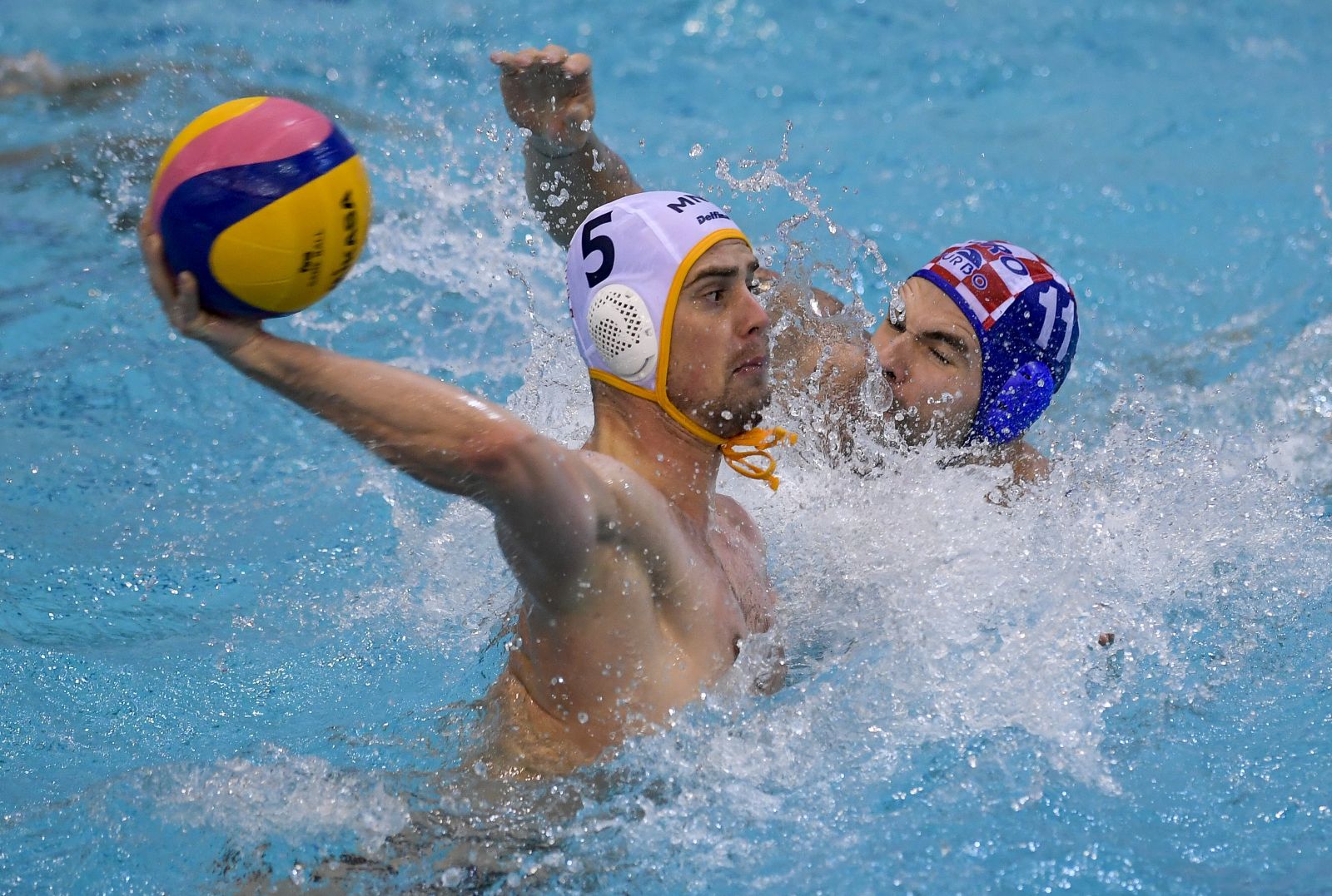 epa08926898 Vlado Popadic (L) of Montenegro is challenged by Hrvoje Benic of Croatia during the Men's Water Polo World League European qualifications' quarterfinal match Montenegro vs. Croatia in Debrecen, Hungary, 08 January 2021.  EPA/Zsolt Czegledi HUNGARY OUT