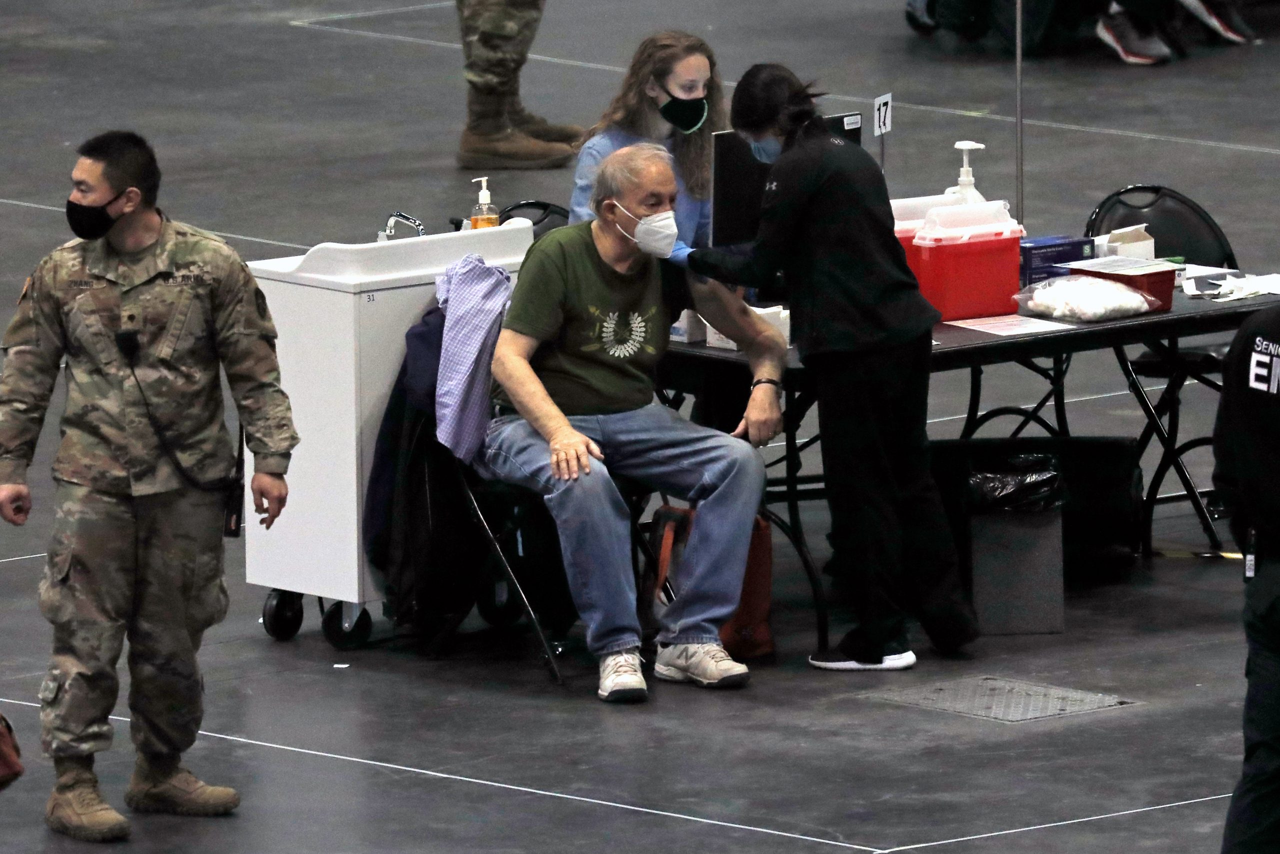 epa08935556 A man recieves a COVID-19 vaccination of the New York State Covid-19 Vaccination Site at the Jacob K. Javits Convention Center in New York, New York, USA, 13 January 2021. With the current CDC directive, seven million New Yorkers are now eligible for the vaccine.  EPA/PETER FOLEY