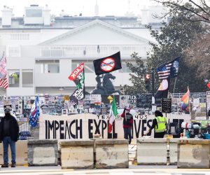 epa08939520 A person with a sign supporting the impeachment of US President Donald J. Trump is seen with the White House in the background in Washington, DC, USA, 15 January 2021. At least twenty thousand troops of the National Guard and other security measures are being deployed in Washington to help secure the Capitol area in response to potentially violent unrest around the inauguration of US President-elect Joe Biden.  EPA/JUSTIN LANE