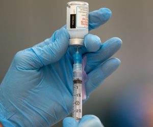 epa08940362 Registered Nurse Connie Gannor prepares doses of a Covid-19 vaccine shot, manufactured by Moderna, at a vaccination center set up in the Rumney Marsh Academy gymnasium in Revere, Massachusetts, USA, 15 January 2021. First responders are part of Phase One of the roll-out of vaccinations in the Commonwealth of Massachusetts.  EPA/CJ GUNTHER