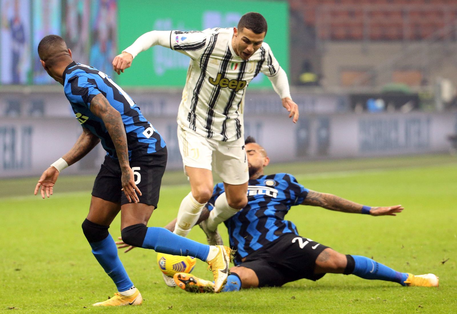 epa08944751 Juventus' Cristiano Ronaldo (C) challenges for the ball Inter's Arturo Vidal (R) during the Italian Serie A soccer match between FC Inter and Juventus FC at Giuseppe Meazza stadium in Milan, Italy, 17 January  2021.  EPA/MATTEO BAZZI
